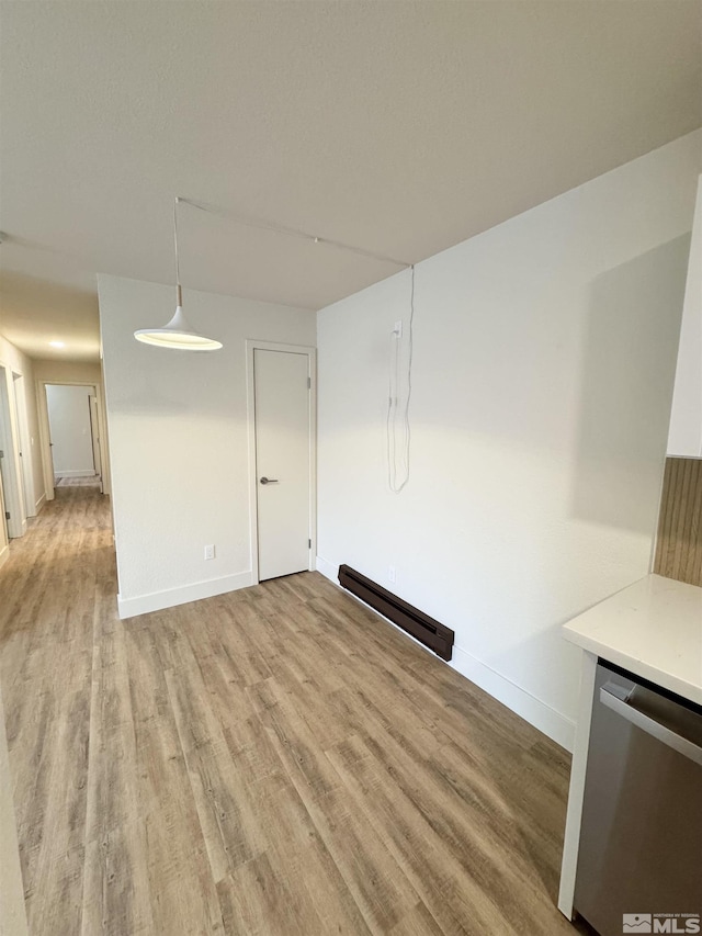 interior space featuring baseboard heating and light hardwood / wood-style flooring