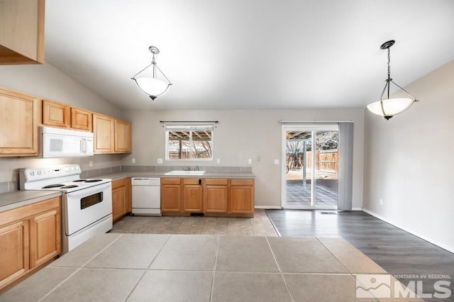 kitchen featuring plenty of natural light, sink, decorative light fixtures, and white appliances