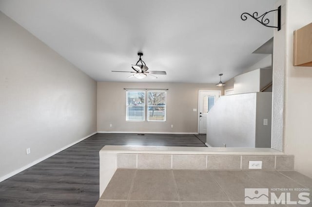 empty room with ceiling fan and dark wood-type flooring