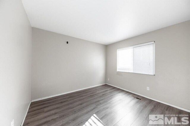 unfurnished room featuring dark wood-type flooring