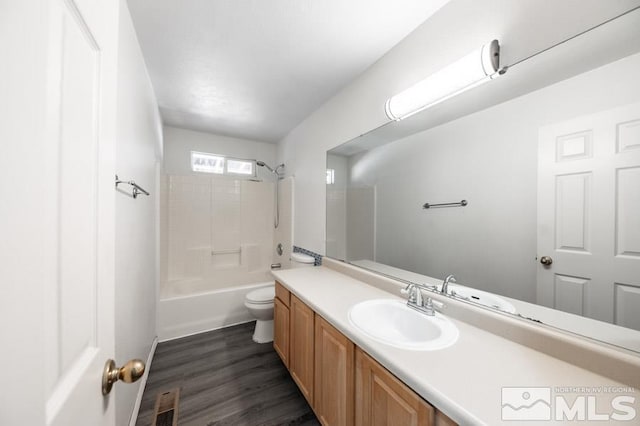 full bathroom with bathtub / shower combination, wood-type flooring, vanity, and toilet