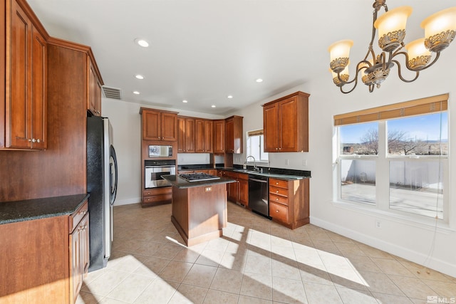 kitchen featuring a center island, sink, dark stone countertops, light tile patterned floors, and appliances with stainless steel finishes