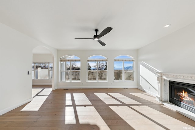 unfurnished living room with ceiling fan and light hardwood / wood-style floors