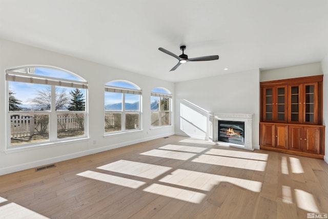 unfurnished living room featuring ceiling fan and light wood-type flooring