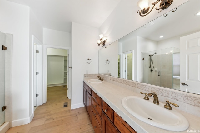 bathroom featuring wood-type flooring, vanity, and a shower with shower door