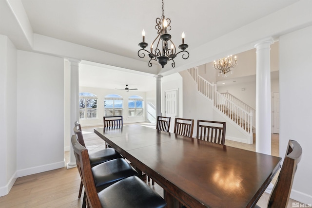 dining space with decorative columns, ceiling fan with notable chandelier, and light wood-type flooring