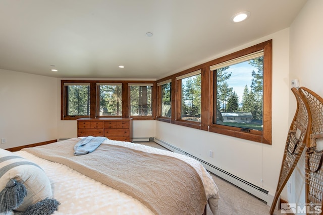 bedroom with carpet floors and a baseboard heating unit