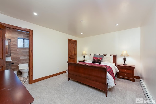 carpeted bedroom with ensuite bathroom and a baseboard radiator