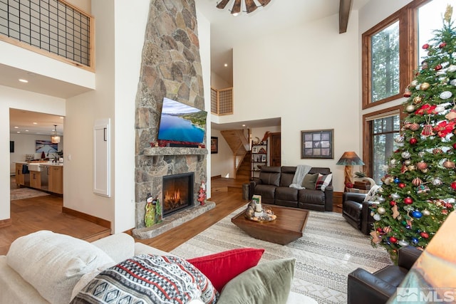 living room featuring a fireplace, a towering ceiling, and hardwood / wood-style floors