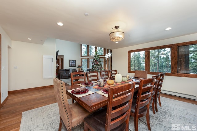 dining room featuring baseboard heating, a healthy amount of sunlight, and hardwood / wood-style flooring