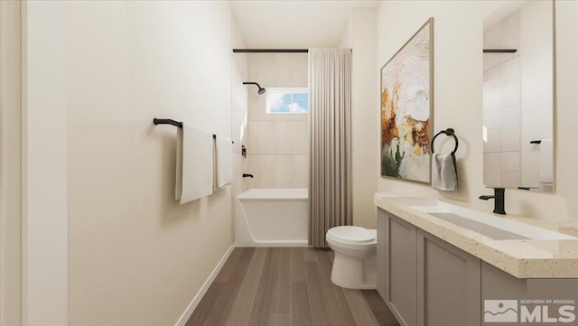 full bathroom featuring vanity, hardwood / wood-style floors, tiled shower / bath combo, and toilet