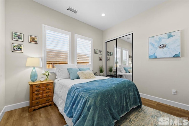 bedroom with wood-type flooring and a closet