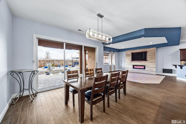 dining room with a large fireplace and hardwood / wood-style floors