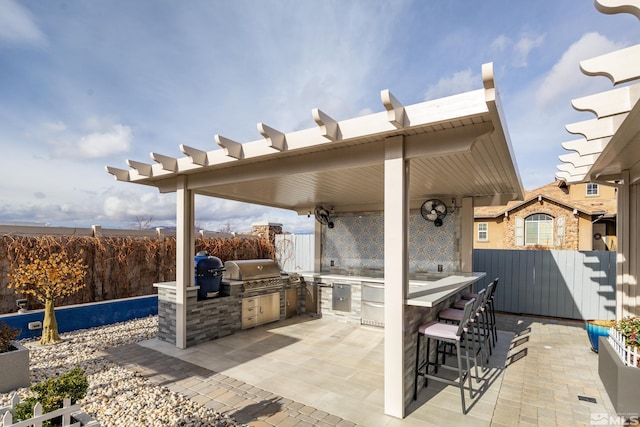 view of patio / terrace with exterior kitchen, area for grilling, and a bar