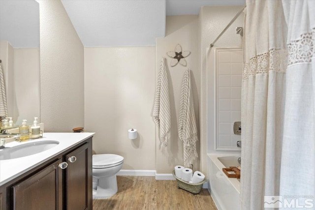 full bathroom featuring hardwood / wood-style floors, vanity, toilet, and shower / tub combo with curtain