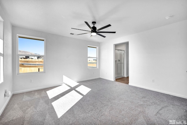 unfurnished bedroom with ceiling fan, multiple windows, and light carpet