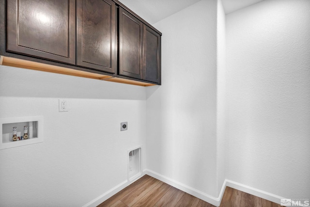 washroom featuring cabinets, hookup for an electric dryer, hookup for a washing machine, and light hardwood / wood-style flooring