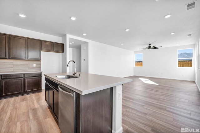 kitchen featuring dark brown cabinetry, sink, an island with sink, ceiling fan, and light hardwood / wood-style floors