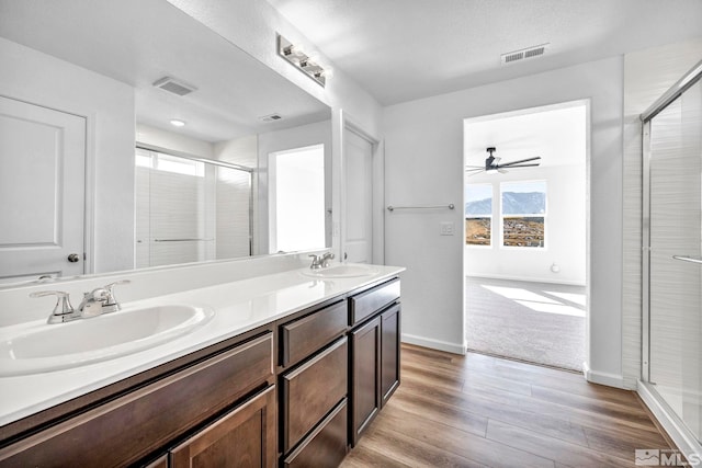 bathroom featuring hardwood / wood-style flooring, vanity, ceiling fan, and a shower with shower door