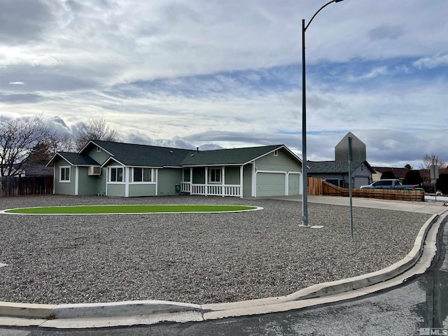 single story home with a wall mounted AC, a porch, and a garage