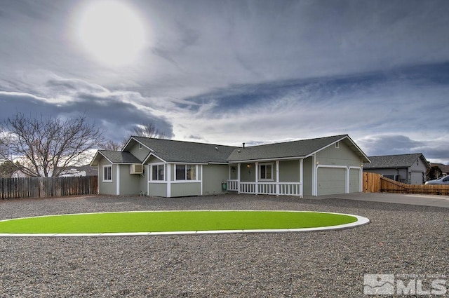 single story home featuring cooling unit, a porch, a garage, and a wall mounted AC