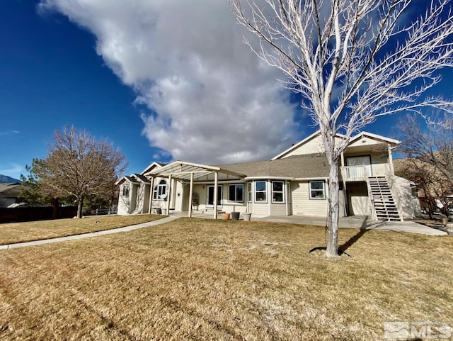 view of front of property featuring a pergola, a front lawn, and a patio area