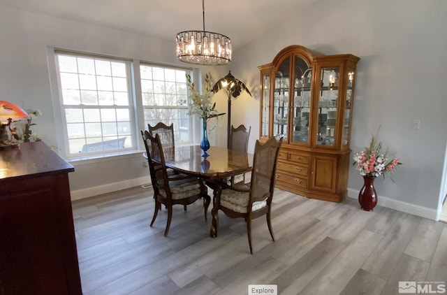 dining space featuring light hardwood / wood-style flooring and a chandelier