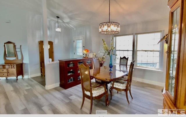 dining room with an inviting chandelier and light hardwood / wood-style flooring