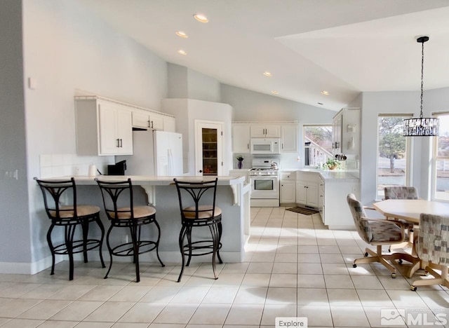 kitchen featuring white cabinetry, a kitchen breakfast bar, kitchen peninsula, white appliances, and light tile patterned floors