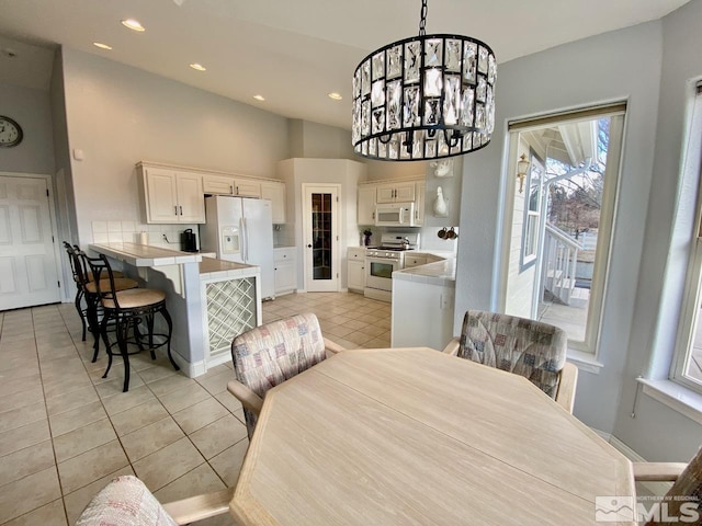 tiled dining space with a notable chandelier