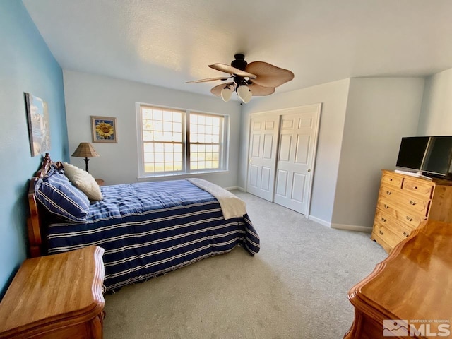 carpeted bedroom with ceiling fan and a closet