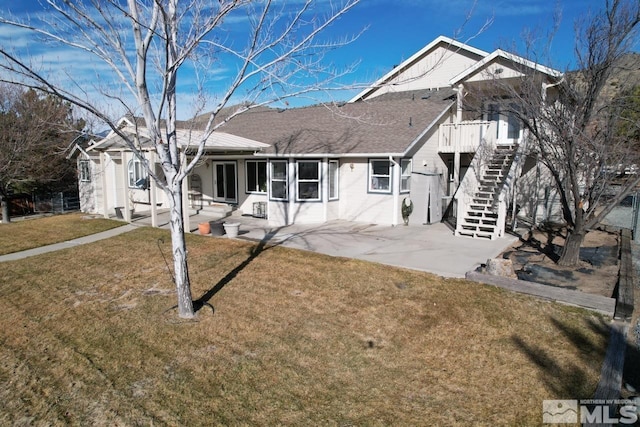 view of front of home with a front yard and a patio