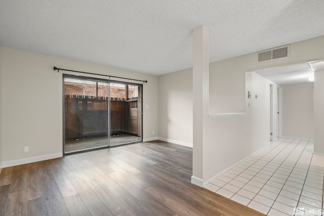 unfurnished room featuring a textured ceiling and hardwood / wood-style flooring