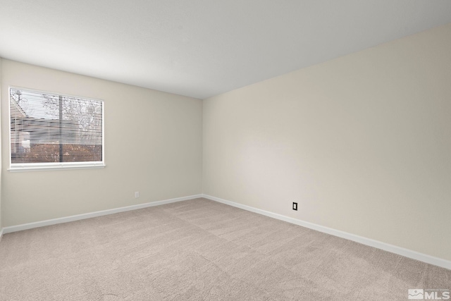 spare room featuring light colored carpet