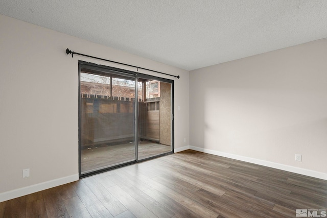 empty room featuring wood-type flooring and a textured ceiling