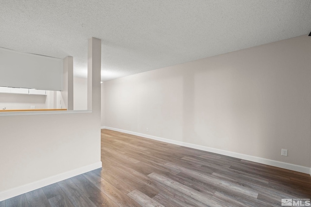 spare room featuring a textured ceiling and hardwood / wood-style flooring