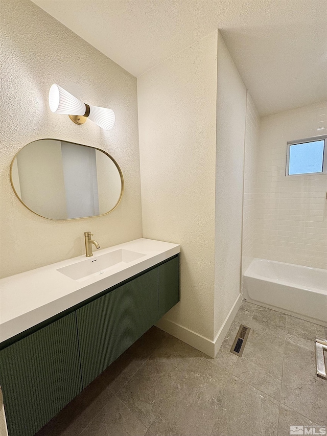 bathroom with vanity and tiled shower / bath