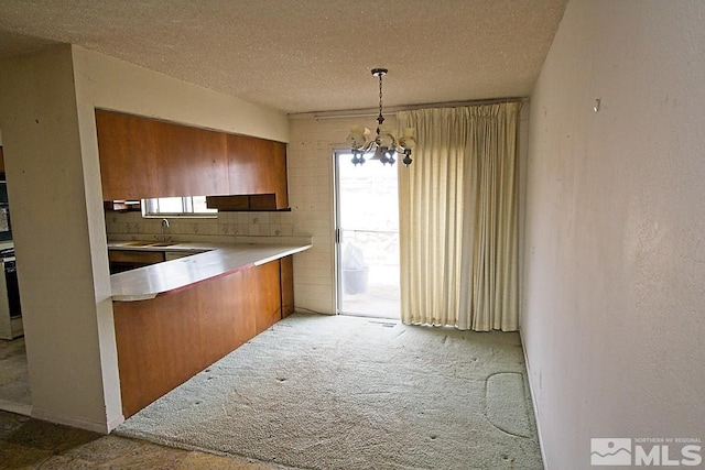 kitchen featuring a chandelier, pendant lighting, a textured ceiling, and light colored carpet