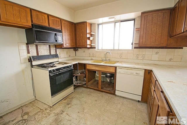 kitchen with decorative backsplash, sink, and white appliances