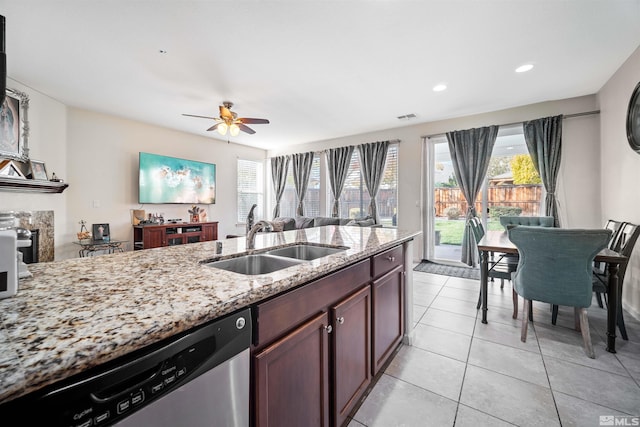 kitchen with ceiling fan, sink, light stone counters, stainless steel dishwasher, and light tile patterned flooring