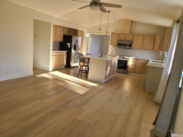 kitchen featuring sink, tasteful backsplash, pendant lighting, a kitchen island, and appliances with stainless steel finishes