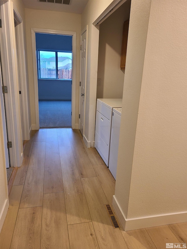 hallway featuring washer and dryer and light wood-type flooring