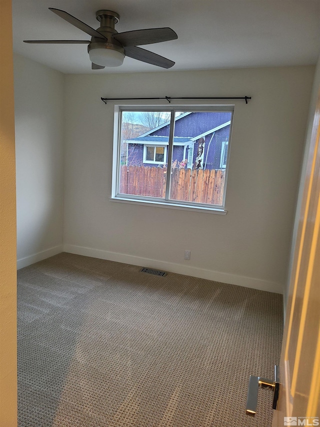 unfurnished room with ceiling fan and carpet