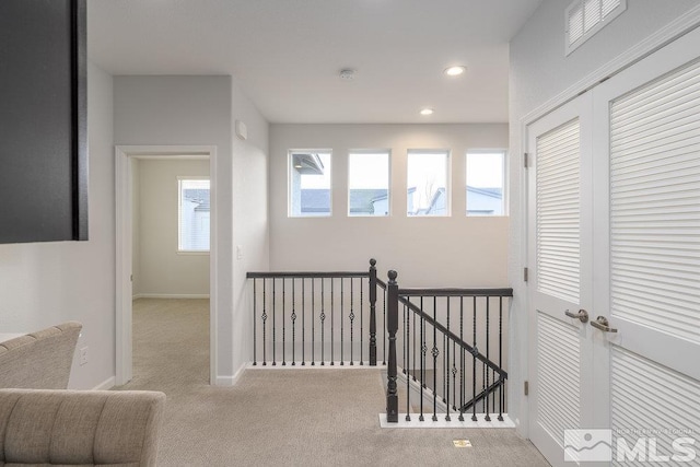 hallway with light colored carpet