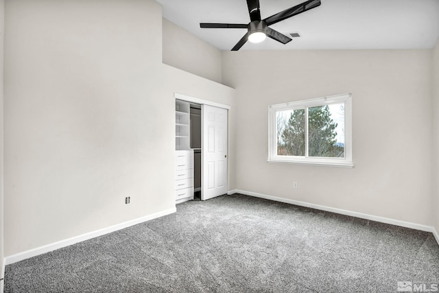 unfurnished bedroom featuring ceiling fan, a closet, carpet floors, and vaulted ceiling