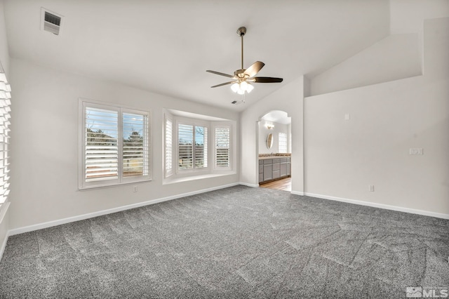 unfurnished living room featuring carpet floors, vaulted ceiling, and ceiling fan