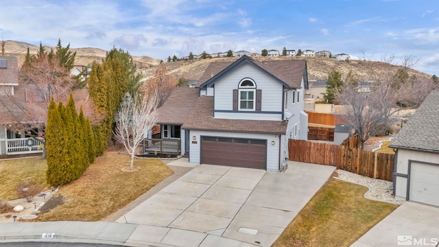 view of front property with a mountain view, a front yard, and a garage