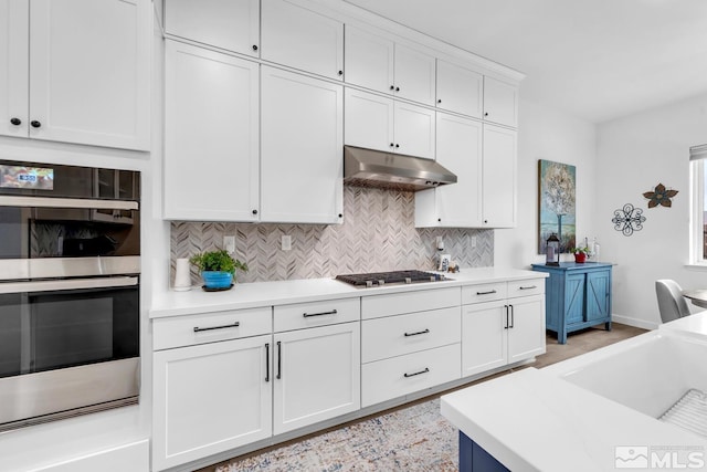 kitchen with tasteful backsplash, white cabinetry, and stainless steel appliances