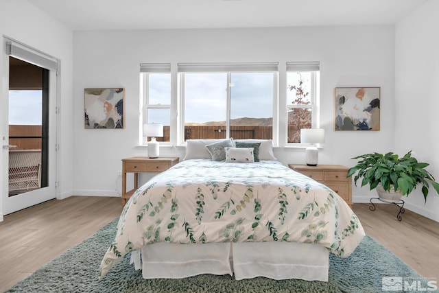 bedroom featuring light hardwood / wood-style floors and access to exterior