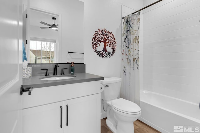 full bathroom featuring shower / bath combination with curtain, vanity, ceiling fan, hardwood / wood-style floors, and toilet